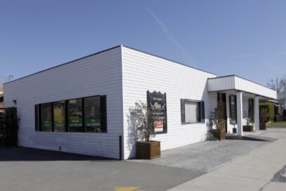 Corner storefront with black window frames and entrance
