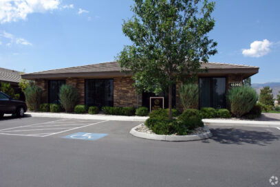 Stone office building with tree and handicap parking